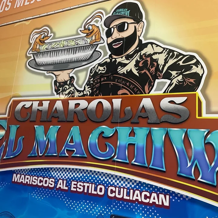 El Machiwi's cartoon chef holding up a charola, as painted on his trailer
